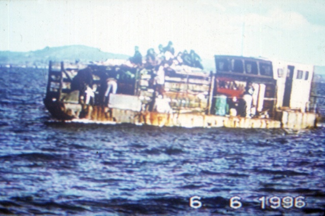 Housing materials on a fully loaded cow barge, with only 500mm of freeboard, are heading to Mōtītī Island, 1996.