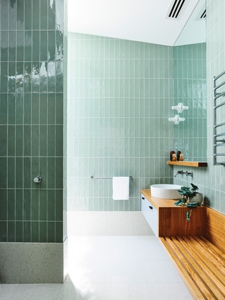 The upper-level ensuite is tiled in an inviting green that references the home’s easy connection with nature.