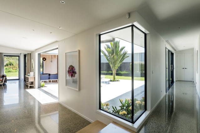 From the entrance and media room, you look right along the hallway, left to the kitchen and living areas and straight ahead, through a glazed corner unit, into the central courtyard.