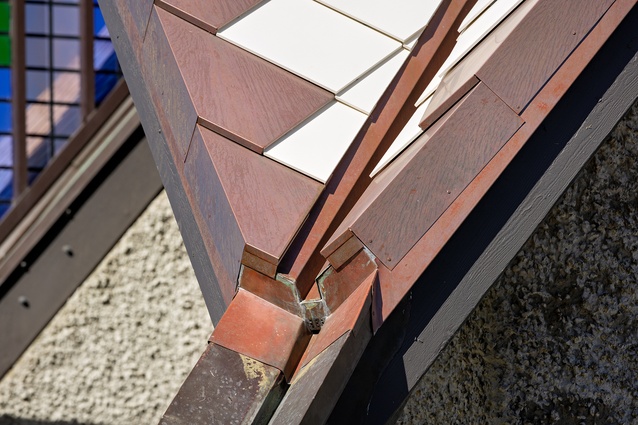 New valley flashing terminating in existing rainwater spout.