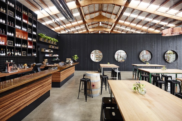 Four Pillars distillery in Australia by Matthews McDonald Architects. The building reflects the gin's hip brand with black-stained timber walls and almost nautical-like port holes that peek into the distilling room.