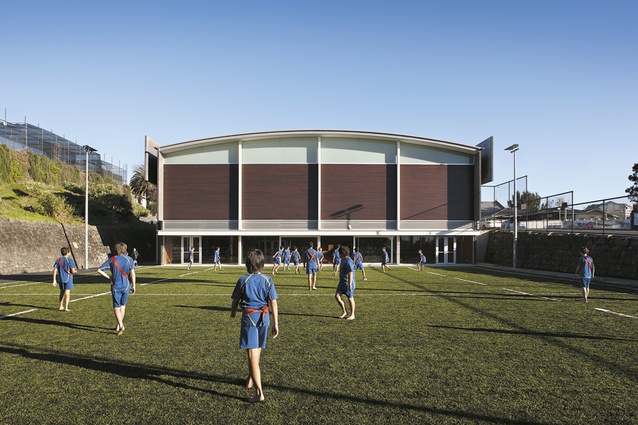 A playing field is situated at the eastern end of the sports centre. In section the new building is a simple form with a gently curving roof. The exterior combines cedar weatherboards and honed concrete blockwork.