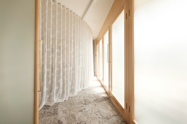 Sheer divider curtains, and soft, textured carpeting within the casket viewing area create a comforting atmosphere.