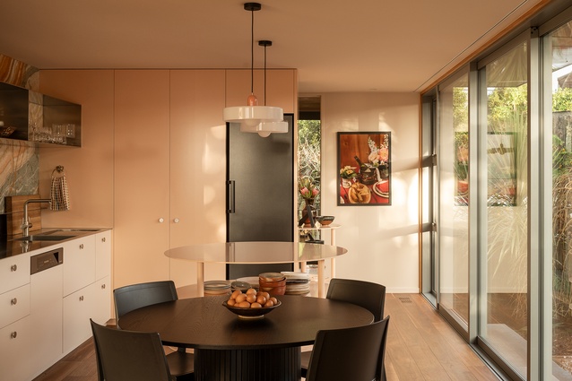The playful colour palette of the kitchen with the peach cabinetry and rainbow onyx splashback.