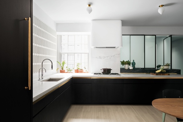 White marble countertops complement the kitchen’s lacquered and ebonised oak pantry.