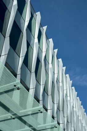The main façade is high-performance glass with expressed vertical mullions.