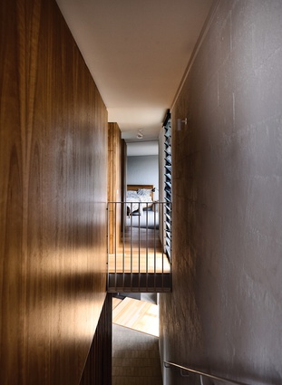 A stairwell along the western edge leads from the entryway to the living spaces and main bedroom on the upper level.