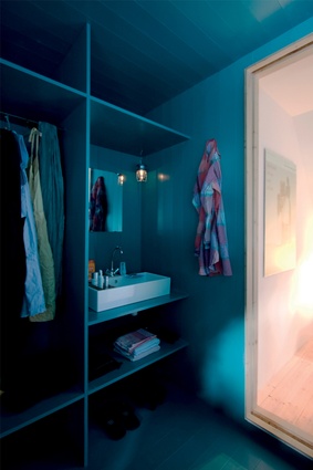 A vivid shade of turquoise lines the walls of this wardrobe, which is also home to a discreetly placed washbasin. 