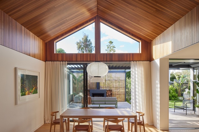 The cedar-clad ceiling wraps down the walls into a band surrounding the dining and living spaces. 