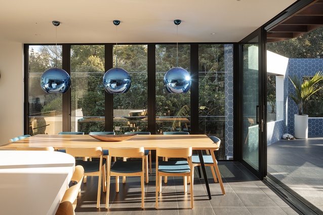 Reflective blue light fixtures hang above the dining table.