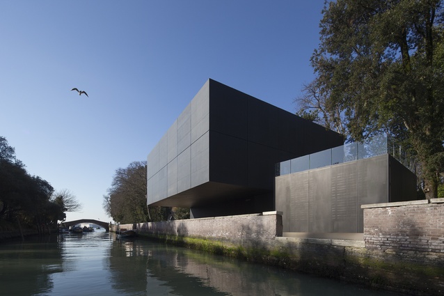 The pavilion's box-like form over a canal in the historic Giardini della Biennale. 