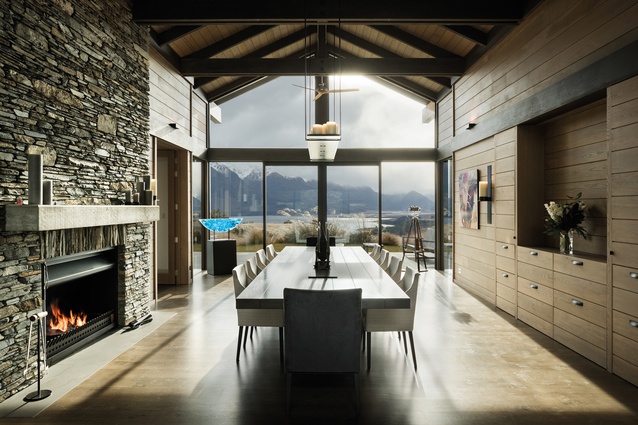 The dining room opens onto a terrace overlooking the lake. The cabinets inset into the wall on the right open electronically to reveal a bar. Drawer pulls for these cabinets are leather.