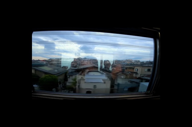 A video still from SoraAI prompt: <em>Reflections in the window of a train travelling through the Tokyo suburbs</em>.