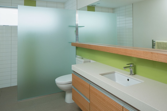 A vibrant green was chosen for the downstairs bathroom. A walk-in shower with single glazed panel keeps the space low maintenance.