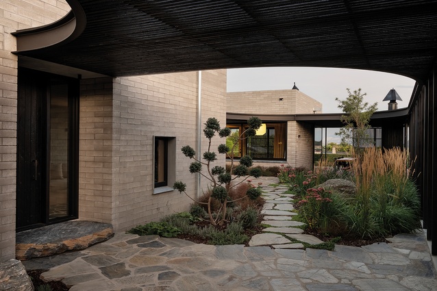 In the crazy-paved arrival court, looking down the garden path to the lounge and lanai at the rear of the house.