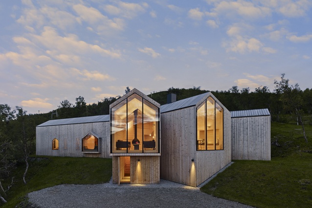 This cabin in the Norwegian wilderness glows with warmth thanks to its materiality and lighting. 