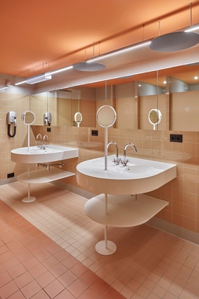 In the bathrooms at CityHub, bespoke sinks and wall cabinets are layered on top of the building's existing structures.