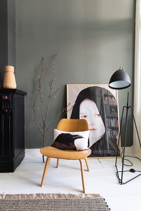The ochre-yellow fibreglass chair is by Eames. Against the wall is a scanned photo by Maurizio Anzeri. The standing lamp is by Flos.