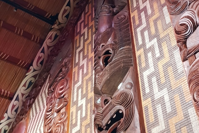 Te Whare Rūnanga – internal rear wall detail, highlighting some of the whakairo (carvings) and tukutuku (woven panels) making up the epa assembly.