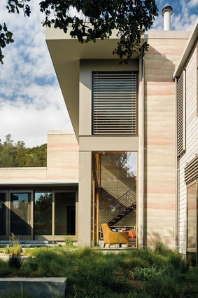 The consistent tones of the rammed-earth walls create texture inside and outside the home.