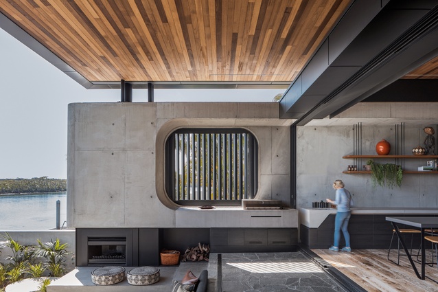 The kitchen bench appears to be carved out of a concrete wall, as does the integrated barbecue outside.