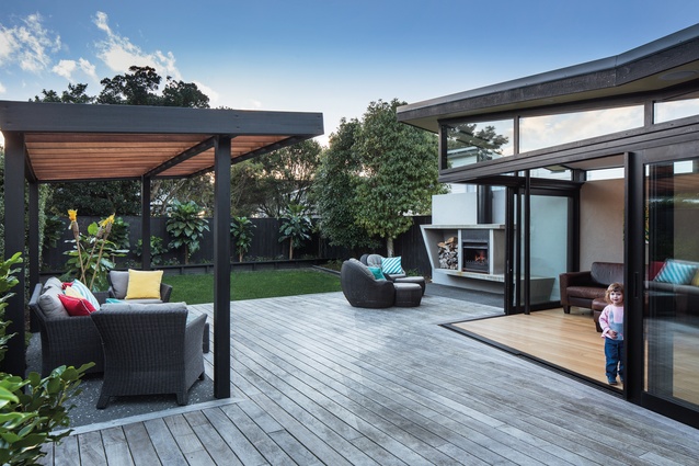 The living room flows seamlessly into the rear courtyard with stacked sliding doors.
