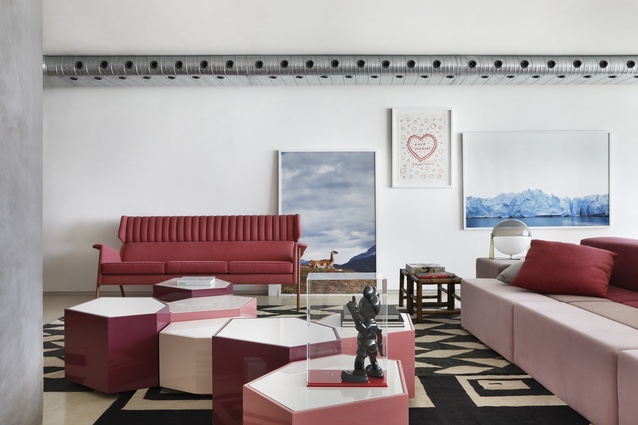 A seeming mismatch of objects, art and furniture is grounded by tones of pink.