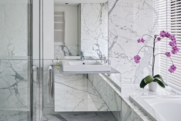 The master bathroom is lined with crisp, white marble.