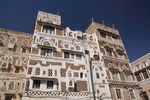 Hand-cut stone buildings in Sana'a, Yemen. These medieval-like towers have high thermal mass and small windows to keep occupants cool. Traditional construction using ancient methods and materials is still widespread in Yemen.