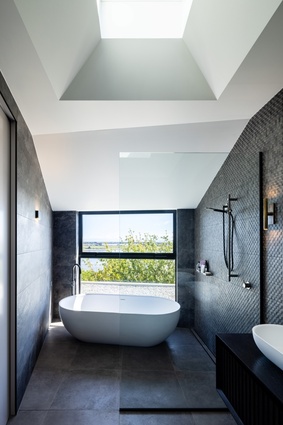 The master bathroom ceiling, like the living room, reaches upwards to a central skylight.
