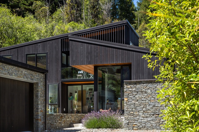 Clad in black cedar, the recessive lakeside house sits quietly on its site.