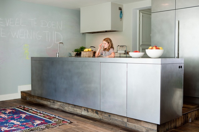 Powder-blue chalkboard paint was used on the wall alongside the stainless steel kitchen. 