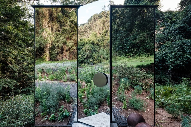 The mirrored box “disappears” into the hillside, creating the perfect bathroom sanctuary.