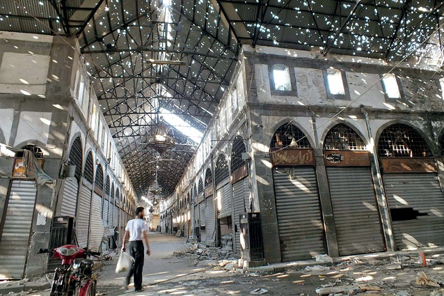 A civilian wanders the bullet-holed roof of the historic Souk Maskouf market in Old Homs in 2013 after Syrian forces took over much of the city which had been held by the so-called rebels, ending a two-year seige.