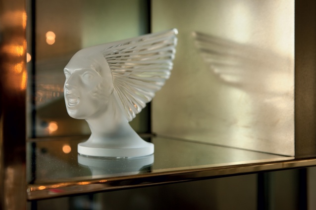 An art deco objét in the private dining room display cabinet. The glasswork is in the style of René Jules Lalique’s Victoire, or the Spirit of the Wind, a type of ornament that was a popular hood adornment on luxury cars 
of the era.