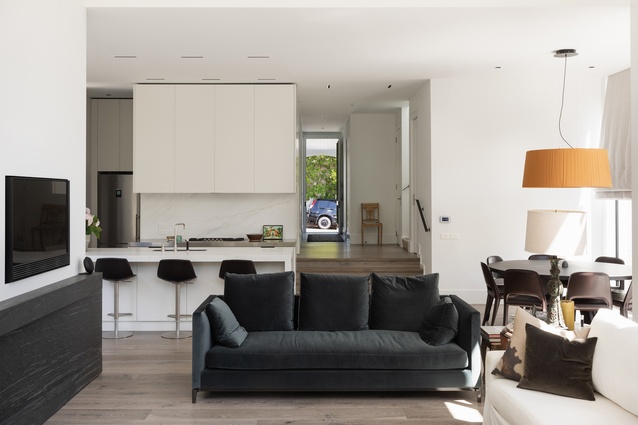 The open-plan living, dining and kitchen area enjoys sunshine throughout the day. The blue <a 
href="https://ecc.co.nz/furniture/indoor/sofas-armchairs/sofa/andersen-slim"style="color:#3386FF"target="_blank"><u>Andersen Slim sofa</u></a> in the living room, also from ECC, is by Rodolfo Dordoni for Minotti. 