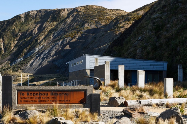 The entrance sign stands in front of the visitor centre and quarry remnants.