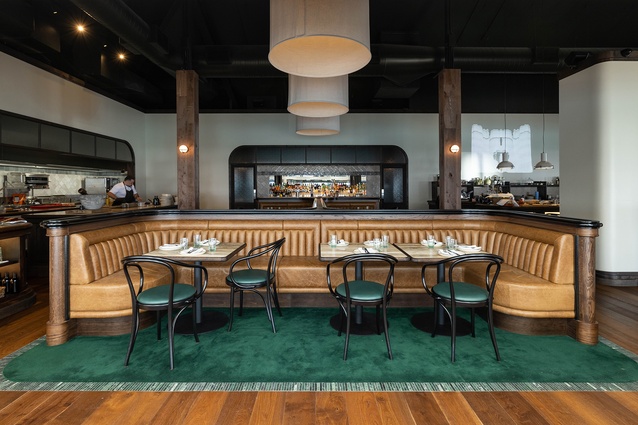 Sumptuous booth seating at Bivacco surrounding an open kitchen on one side, and a more casual set-up around a bar creates a relaxed ambience for diners.