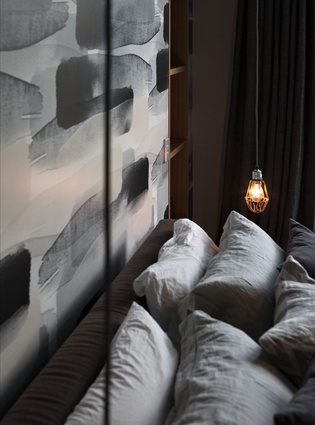 The master bedroom features dark and sultry bed linen. 