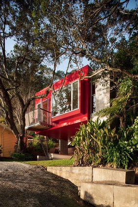 The vibrant shade of red not only references pohutukawa blossoms but also the traditional colour of the older baches.