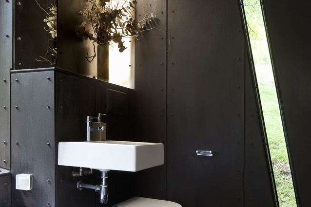 The bathroom has a unique angled window, making a connection to the trees outside.
