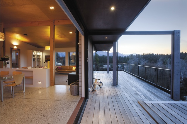 The large open-plan living space has sliding doors that open out onto the deck.