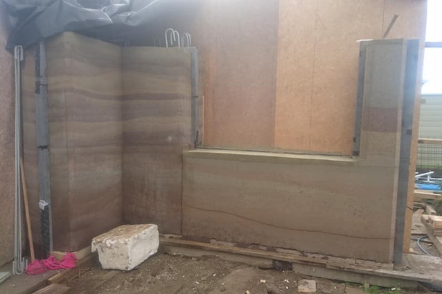 In July, the team began exposing some of the rammed earth walls that were built in June.