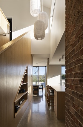 A brick wall runs from outside into the hallway, lending texture and colour to the interior spaces.