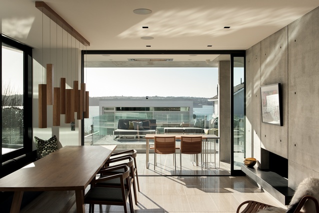 Herne Bay House, Daniel Marshall Architects. The dining area is punctuated by a concrete wall on one side and a glazed well on the other.