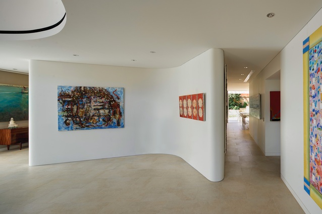 A “wishbone” feature housing a discreet study room helps to divide the lower level into formal and informal spaces. Artwork (L-R): Ann Thomson; John Firth-Smith.
