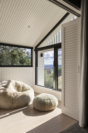 The sunroom, located off the master bedroom, features weatherboard wall linings to give the look of an outdoor space.