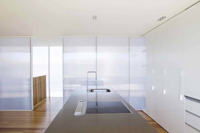 White polycarbonate is used as a dividing wall between the kitchen and the staircase. 