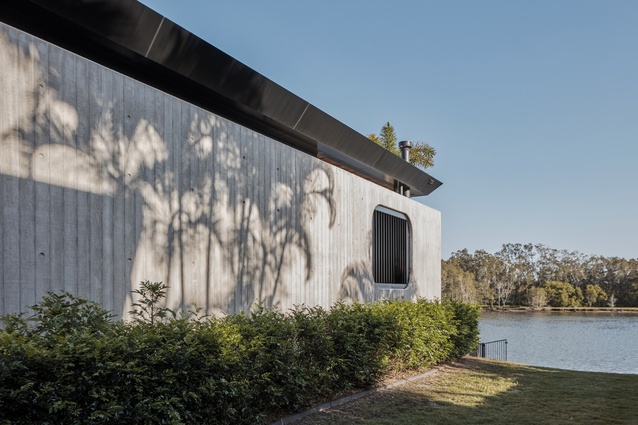 The easement boundary wall is constructed with board-form concrete and communicates the tactile nature of the house.