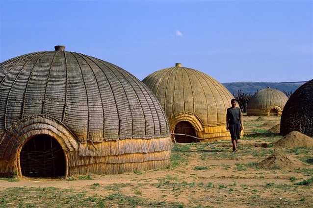 Zulu or "beehive" huts, located along South Africa's eastern coast. Known as <em>iQukwane</em>, they are constructed from layers of grass covering a wooden framework, with extremely low doorways so enemies had to stoop to enter.